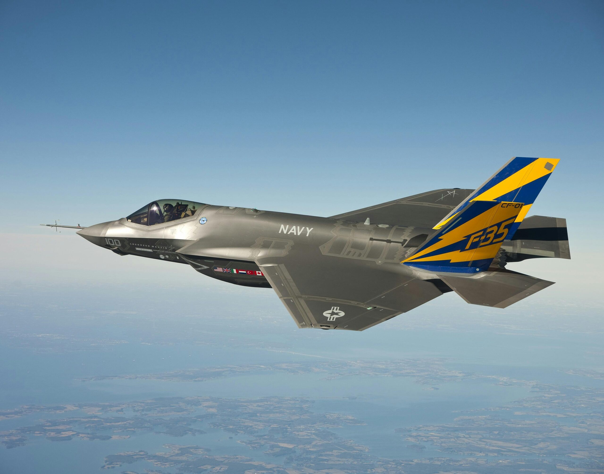 Navy Fighter Plane Flying on Clear Blue Sky over shore